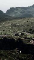 A mountain range with rocks and grass in the foreground video