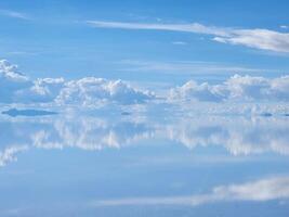 A large body of water with clouds reflected in it photo
