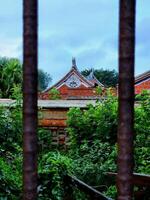 A view of a building through a fence photo