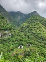 A train is traveling through the mountains on a cloudy day photo
