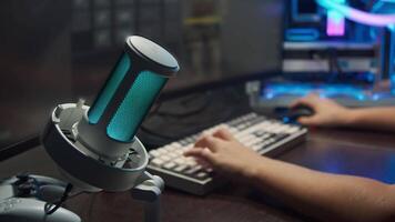 Close-up shot of a multi-colored neon professional microphone, which is recording the voice of a gamer during an online shooting game. video