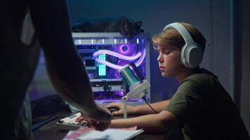 One of parents compels child to complete their homework by directing their attention to textbooks and notebook, rather than engaging in recreational activities on gaming computer. video