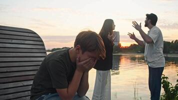 Husband and wife are arguing loudly and angrily in a public setting, while their son covers his eyes in embarrassment and begins to cry. video