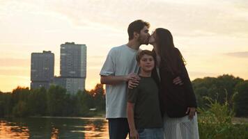 retrato de un familia consistente de dos amoroso padres y su hijo, conjunto en contra el fondo de un alto edificio y un urbano ambiente. video