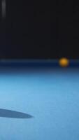 White ball falls into a billiard ball of uniform orange color at number 5 during a game of American pool on a blue billiard table. Vertical video