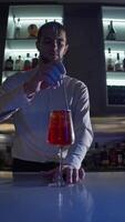 Bartender completes preparation of an alcoholic cocktail by mixing all ingredients with bar spoon. He then moves cocktail directly to customer's position at bar. video