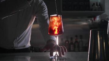Process of making bright summer cocktail, which includes an essence of orange peel. Bartender twists the peel to give the drink a hint of citrus freshness video