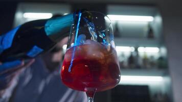 Bartender in a nightclub serves sparkling champagne into a glass filled with ice, creating a refreshing Aperol Spritz cocktail with a hint of orange. Close up. Slow motion video
