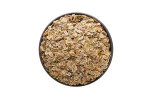 Dill seed in clay bowl isolated on white background. Seasoning or spice top view photo