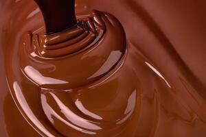 stream melt chocolate spreads in waves. hot cocoa background photo