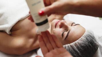 Side view portrait of young relaxed woman on procedure for improvements skin. Concept of special masks and creams for moisturizing. Self care spa concept. Advertising of cosmetology, cleanliness. video