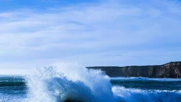 A large wave crashing into the ocean photo