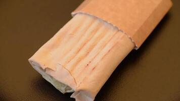 Roll with pita, meat, tomatoes, cheese, sauce, salt and spices on a dark texture background video