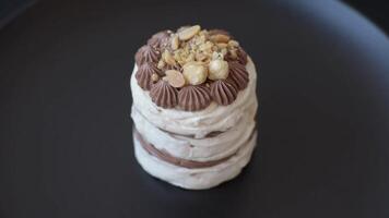 Sweet puff tart with meringue, cream and nuts on a dark concrete background video