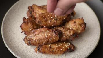 Grilled chicken wings with spices and herbs on a dark concrete background video