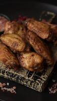 Grilled chicken wings with herbs on a dark concrete background video