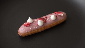 Sweet eclair or profiterole with strawberry custard on a textured background video