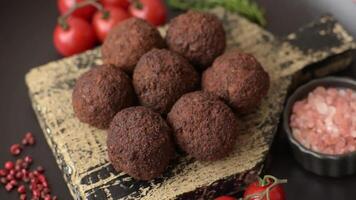Falafel vegetarian and vegan dish made with chickpeas, spices and herbs on a dark concrete background video