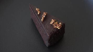Piece of sweet cake with nuts on dark concrete background video