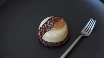 Sweet tart with pear lemon mousse cream and chocolate cake base on a dark concrete background video