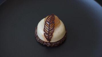 Sweet tart with pear lemon mousse cream and chocolate cake base on a dark concrete background video