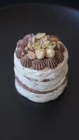 Sweet puff tart with meringue, cream and nuts on a dark concrete background video