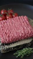 Fresh raw ground beef with salt, spices and herbs on dark concrete background video