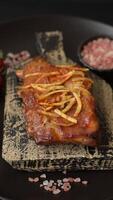 Pork or beef ribs with salt, spices and herbs baked on the grill on a dark concrete background video