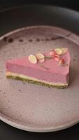 Piece of sweet cheesecake with pink cream cheese of raspberry or strawberry flavor on a dark textured background video
