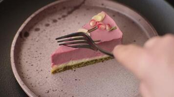 Piece of sweet cheesecake with pink cream cheese of raspberry or strawberry flavor on a dark textured background video