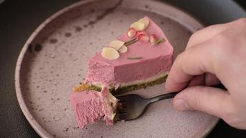 Piece of sweet cheesecake with pink cream cheese of raspberry or strawberry flavor on a dark textured background video