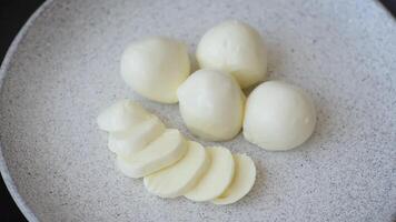 Delicious fresh mozzarella cheese with tomatoes, salt and spices on a dark concrete background video