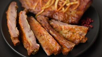 Pork or beef ribs with salt, spices and herbs baked on the grill on a dark concrete background video
