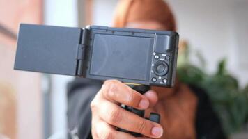 A Person Holding a Camera That Features a Flip Screen for Enhanced Photography and Filming video