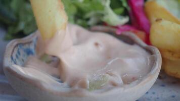 Closeup of crispy fries served with creamy dipping sauce, a delightful appetizer option video