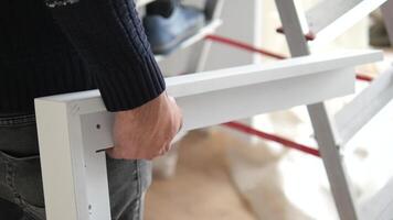 Two hands carefully holding a white frame while working on a home improvement project video