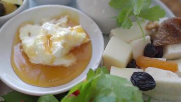 butter cream and honey in a bowl on table . video