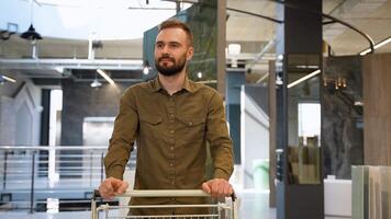 Handsome man walking with trolley at luxury shop and chooses tiles video