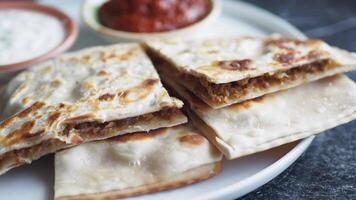 A Delicious Flatbread Served with a Variety of Dipping Sauces Arranged Neatly on a White Plate video