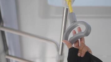 woman holding a row of yellow handle on a bus video