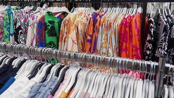 A vibrant collection of stylish summer shirts displayed on hangers in a retail store video