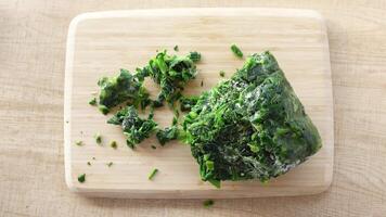 frozen chopped serving of spinach, beautifully arranged on a rustic wooden cutting board video