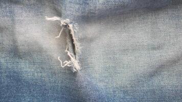 blue jean texture with a hole and ripped threads showing video