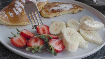 Indulgent and Fluffy Pancakes Topped with a Fresh and Colorful Medley of Strawberries and Bananas video