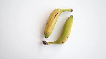 Child Hand Holding Two Ripe Bananas on a Bright Surface video