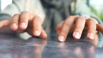 A closeup view showcasing hands resting elegantly on the smooth surface of a table video