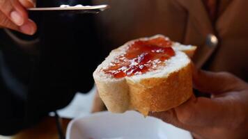 Enjoying the delightful experience of spreading delicious jam on a fresh slice of bread video