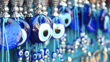 a bunch of blue evil eye keychains hanging on a shelf video