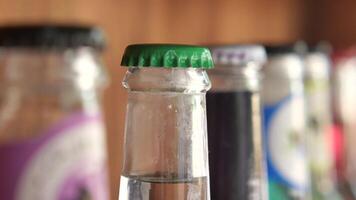 Vintage beverage bottles with colorful caps on bar shelf create a nostalgic retro drinks display video