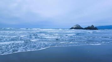 A view of the ocean and some rocks on the beach photo
